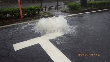 写真:永山橋付近のマンホールからあふれる水