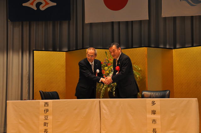 写真：握手を交わす多摩市長と西伊豆町長