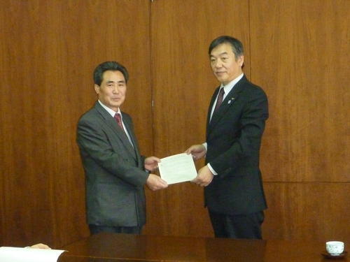 写真：市長と協定書を交わす東京すみれ会理事長緑川徳光氏