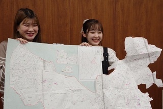 写真：ソーラー台帳（地図）と清水紗良さん（左）、荒巻可奈さん（右）