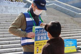 写真：募金をする黒い服を着た子ども