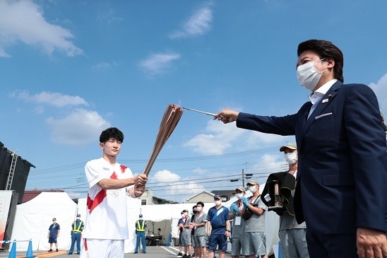 写真：藤原市議会議長によりリレー第一走者のトーチへ聖火が点火される様子