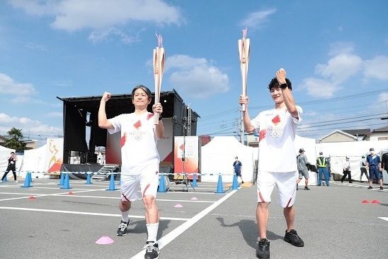 写真：トーチキス後に決めポーズをとる走者たちの様子