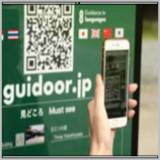 写真：「Guidoor（ガイドア）」ポスターの前のスマートフォン