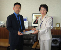 写真：株式会社グリーン・ワイズの田丸雄一社長と多摩市長（指定企業第16-1号）