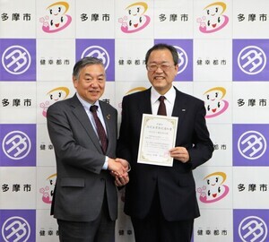 写真:握手をするKDDI株式会社の田中会長と阿部市長(指定企業第31-1号)