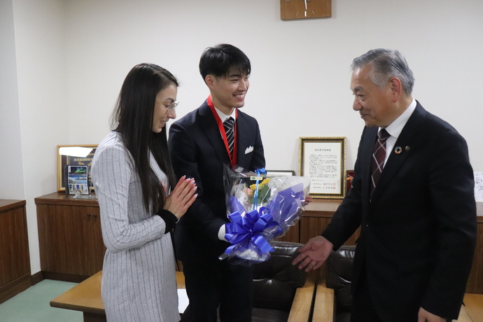 花束を贈呈する多摩市長