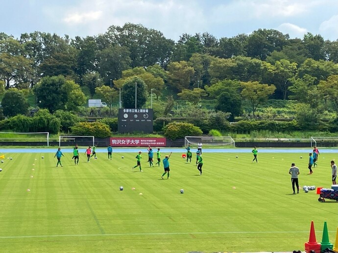 陸上競技場でサッカーをする参加者の写真