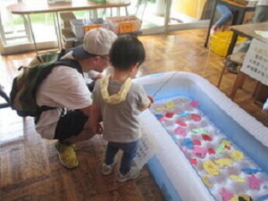 魚釣りゲームをしている親子の写真