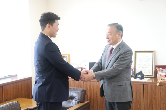 金子選手と阿部市長が握手している様子