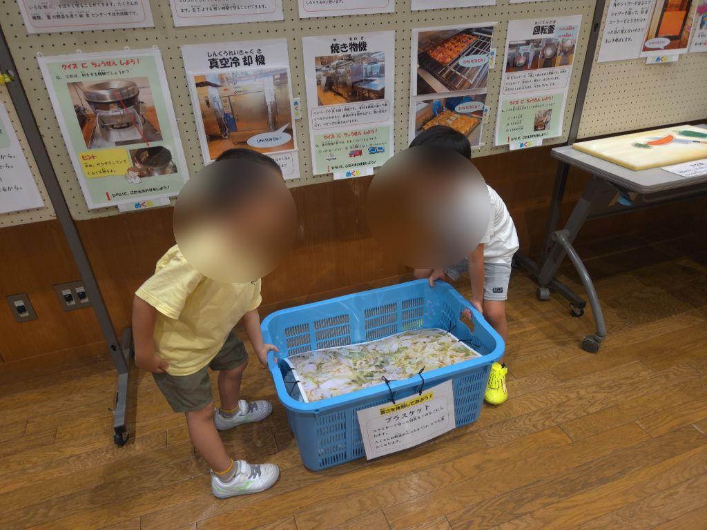 重たい野菜を持ってみる様子