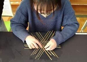 ヒネを編んで敷きザルを作っている写真